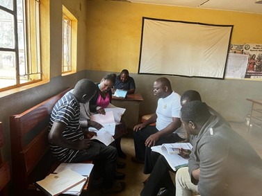 Photo: Ministry of Health staff using the Malaria DQA job aid to conduct data verification in one of the CHISU supported districts.