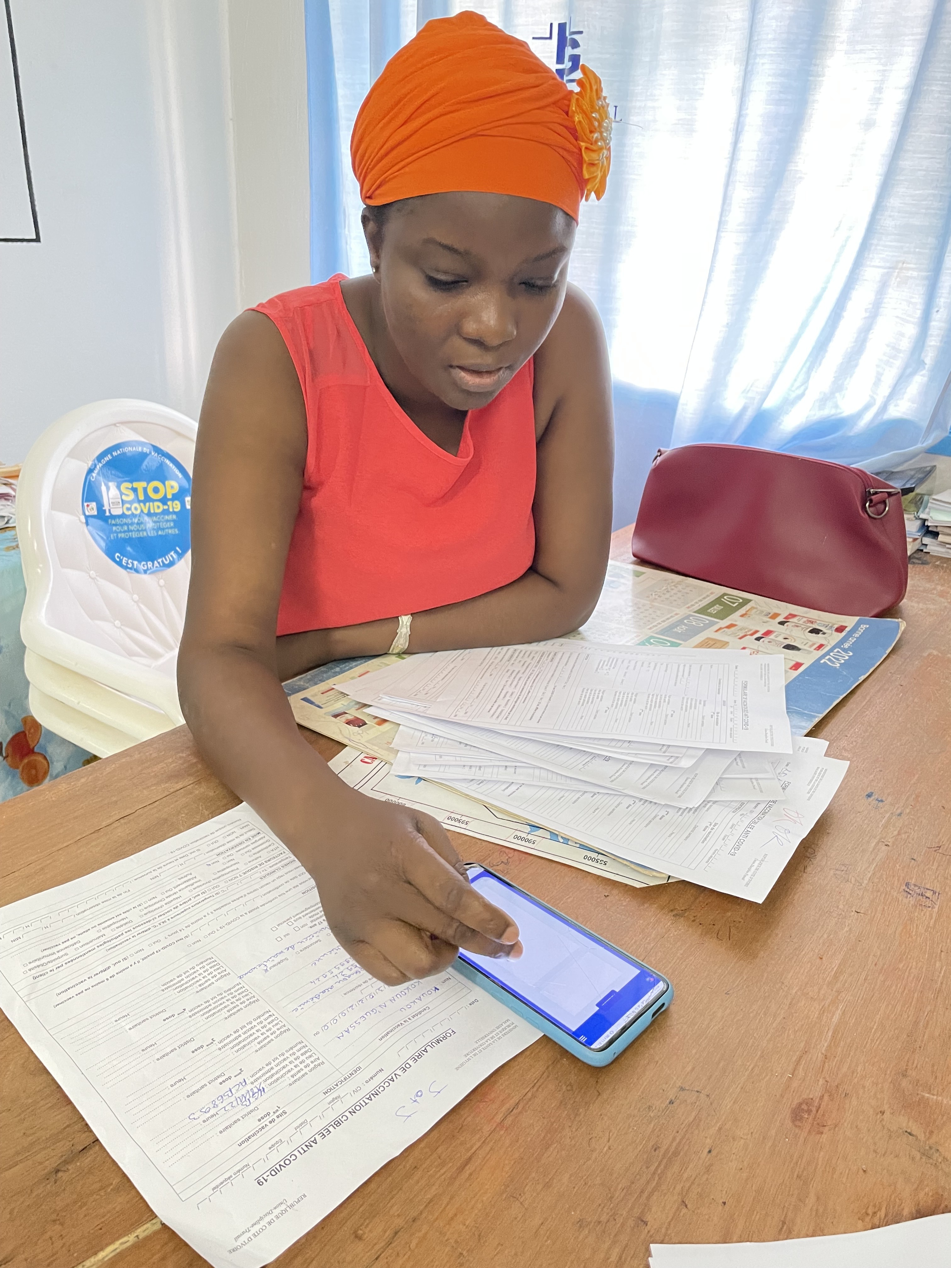 Ouattara Fatoumata, a midwife, checks data entries on her cell phone. 