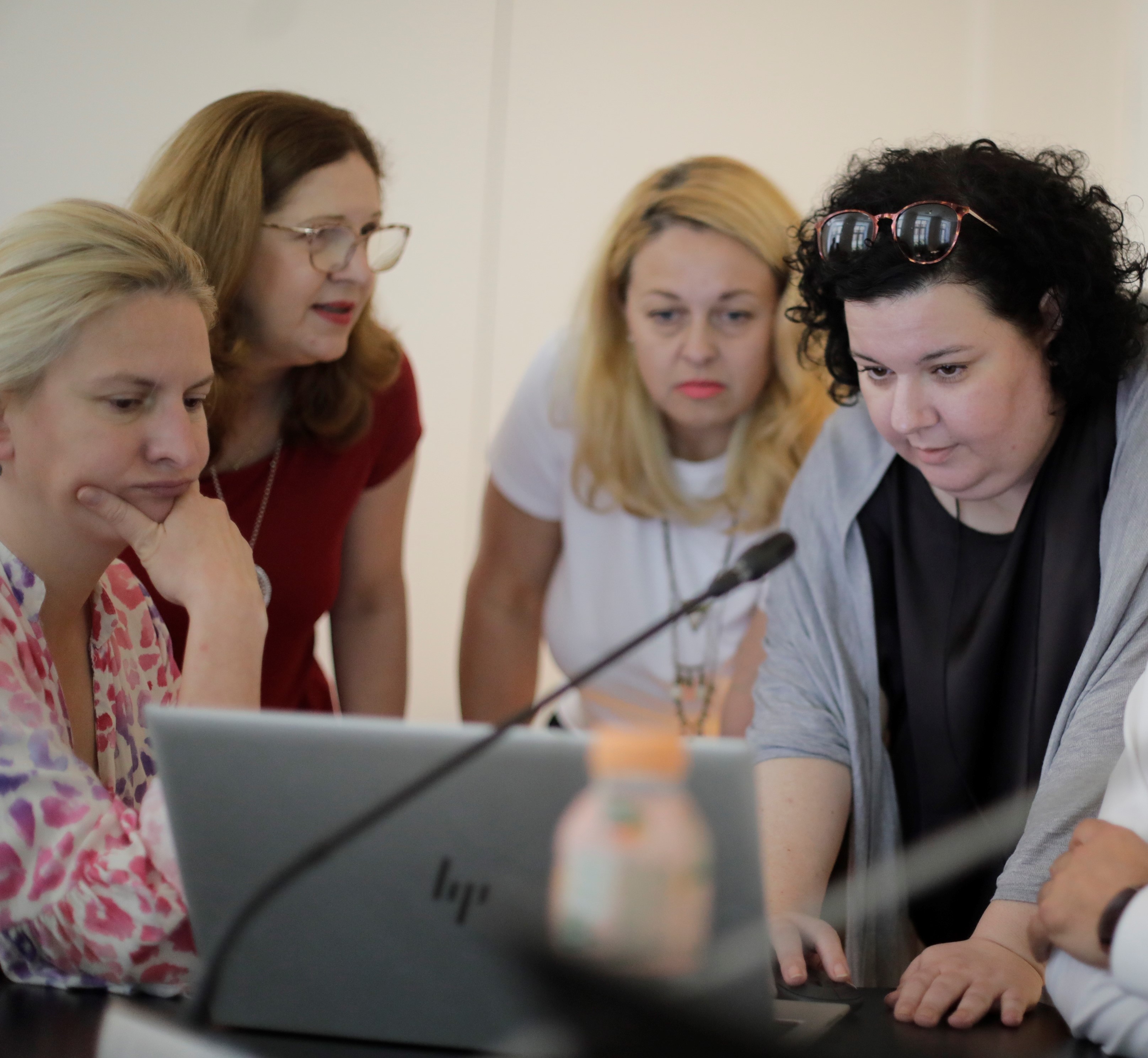 People look at a laptop screen together at a workshop.