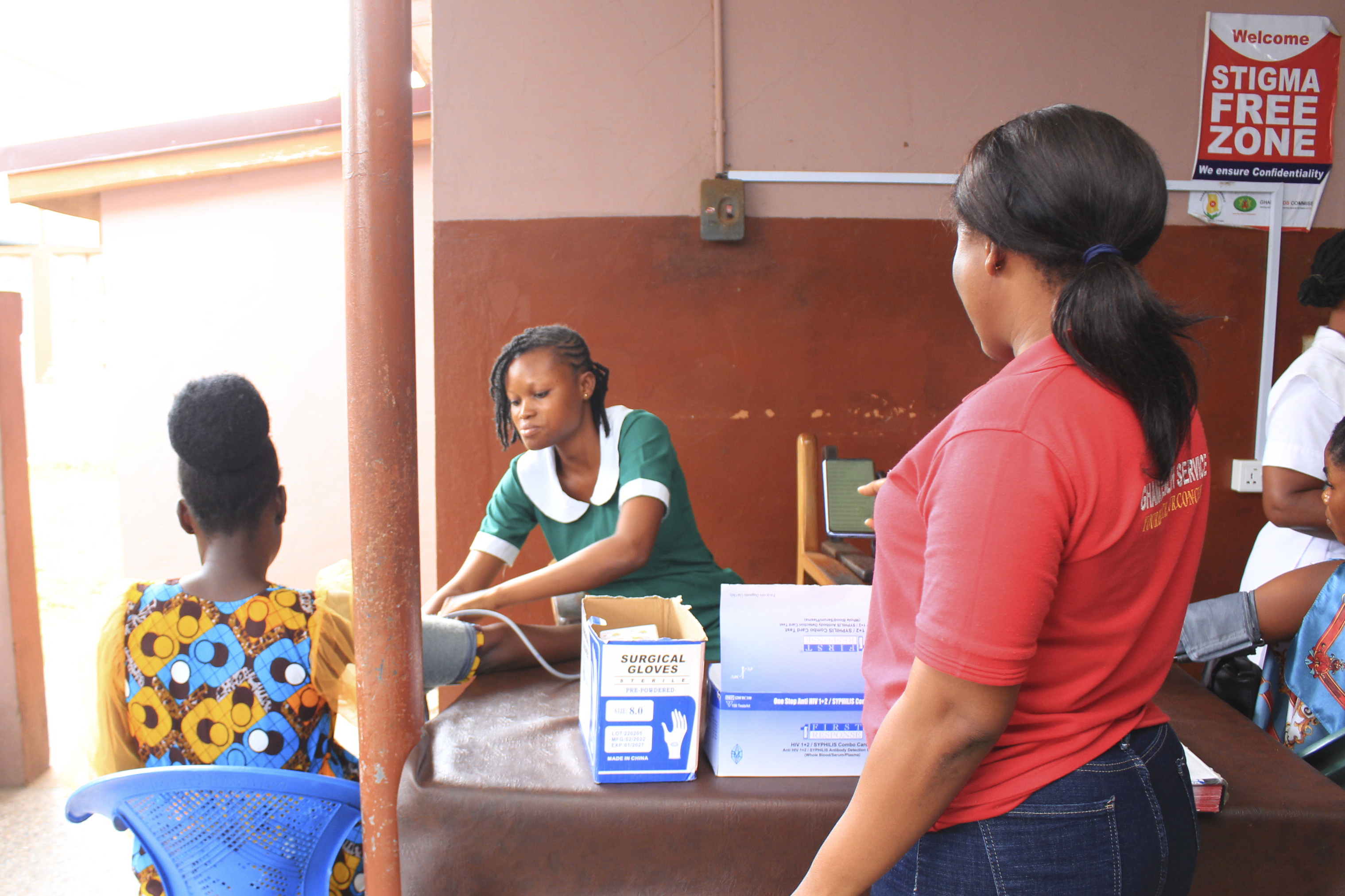 A woman conducts direct observational supervision of nurse/midwife conducting antenatal care services with a client.
