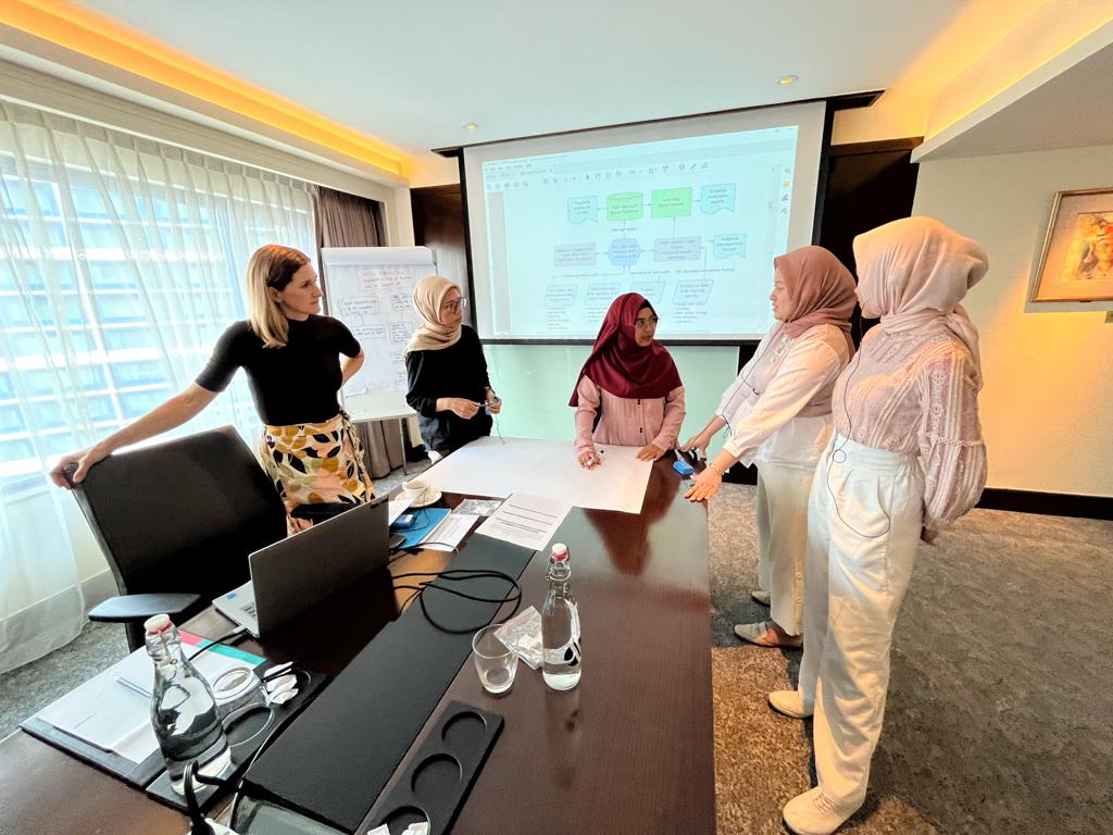 Five women meeting in a conference room