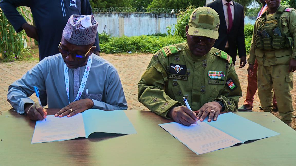 Two men signing papers