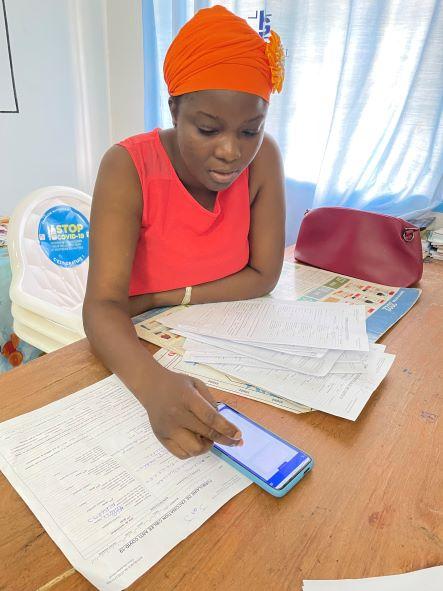 Ouattara Fatoumata, a midwife in the Ivory Coast, checks data entries on her cell phone. 