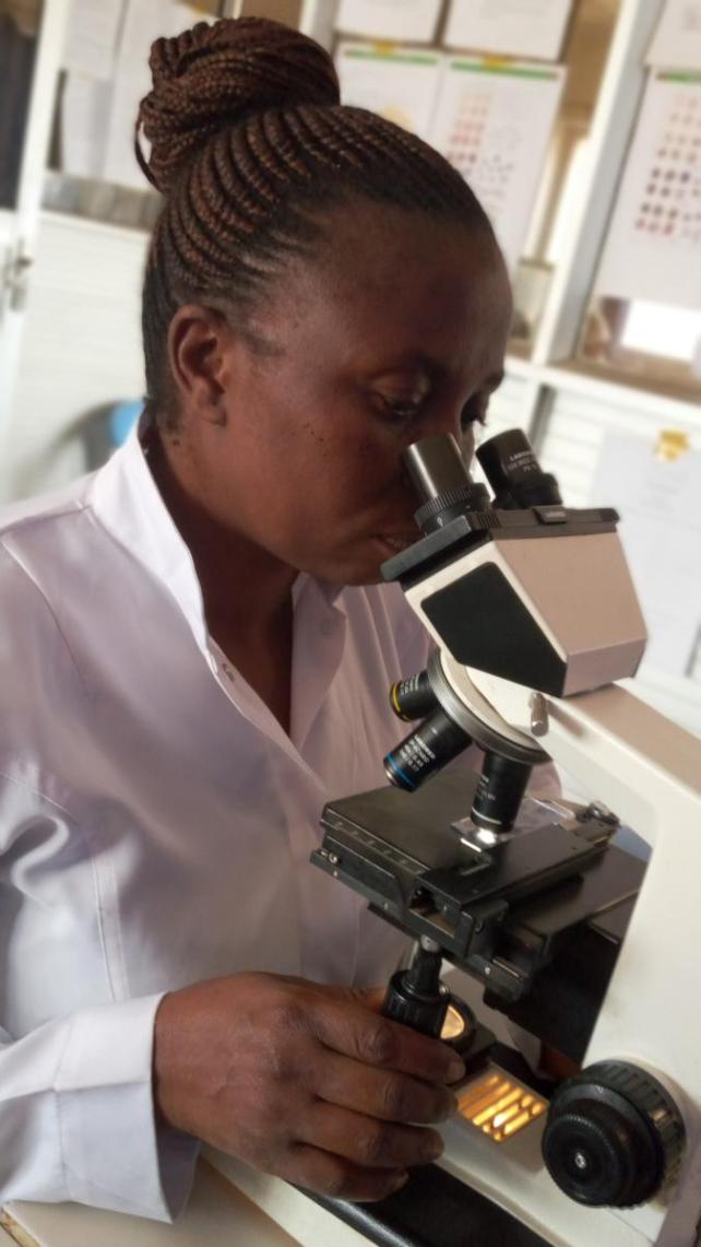 Woman looks into a microscope