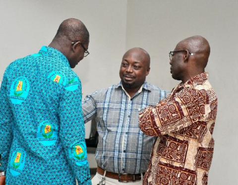 Three men standing around talking with each other