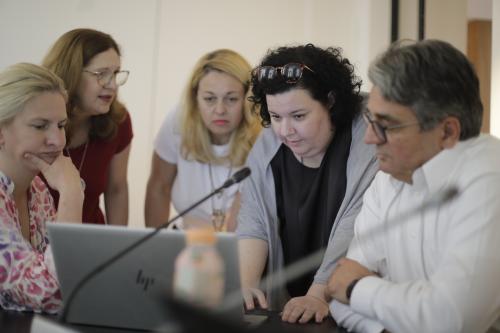 People look at a computer screen together at a workshop.